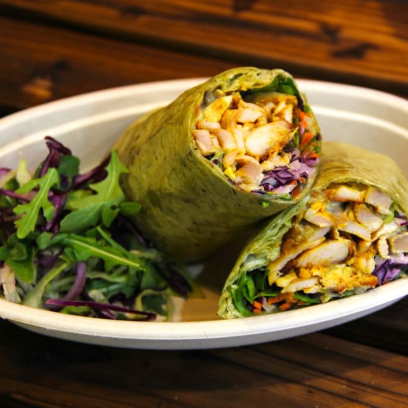 Two Mr.Cone Shawarma wraps with chicken, vegetables, and a side salad on a white plate.