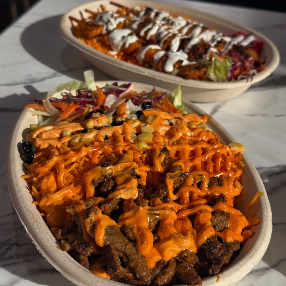 Two Mediterranean shawarma bowls, one with beef and orange sauce, the other with chicken and white sauce.